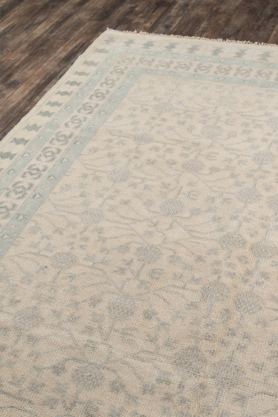 Erin Gates x Momeni Concord CRD-2 Ivory and pale blue transitional area rug with hand-knotted wool blend, featuring sun-bleached geometric borders on dark wood flooring.