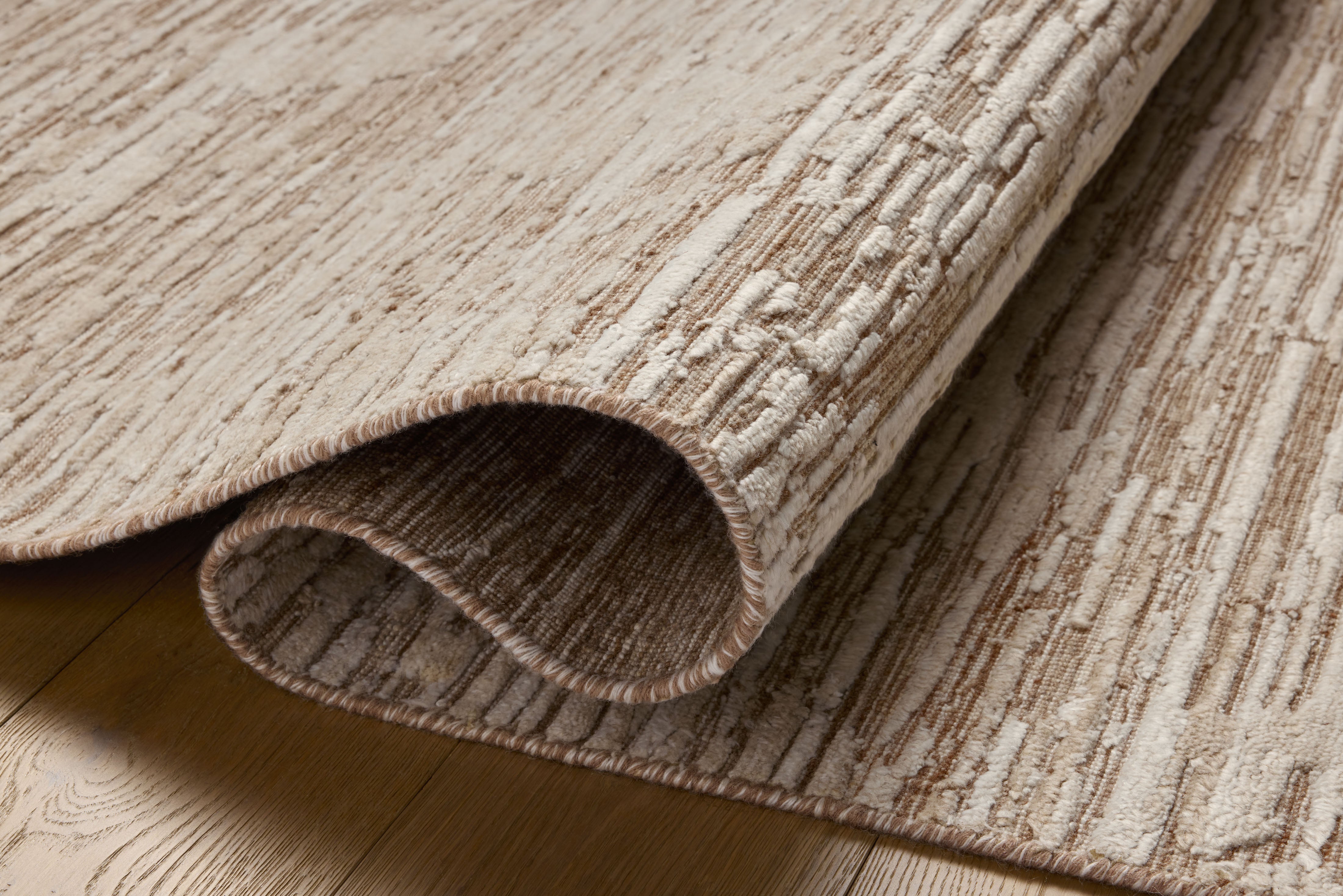 Finished in warm natural tones with ribbed and graphic styling, the Daniel DAN-02 Natural Area Rug is a hand-loomed bamboo and wool area rug for modern living