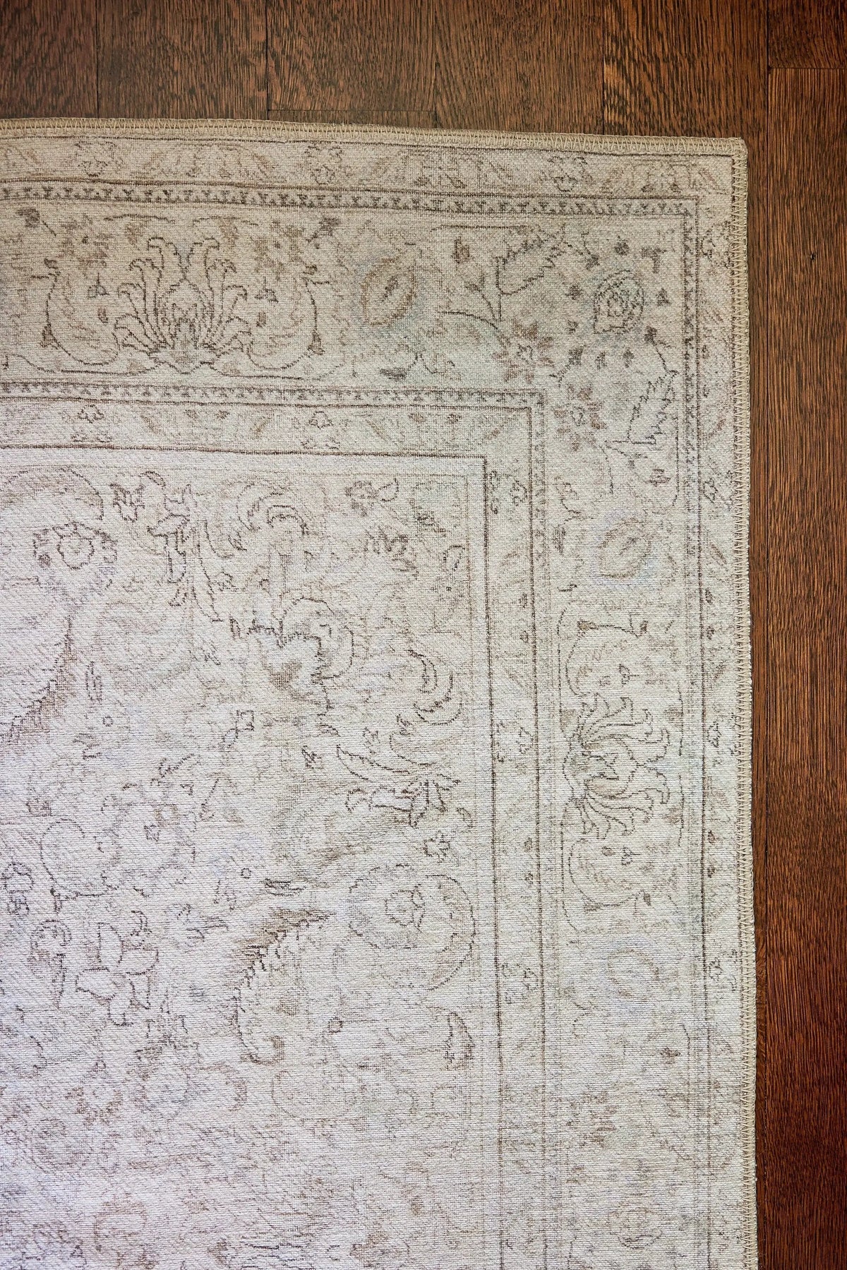 Erin Gates by Momeni Dorset DOR-4 gray area rug with vintage design and distressed floral details on dark wood floor.