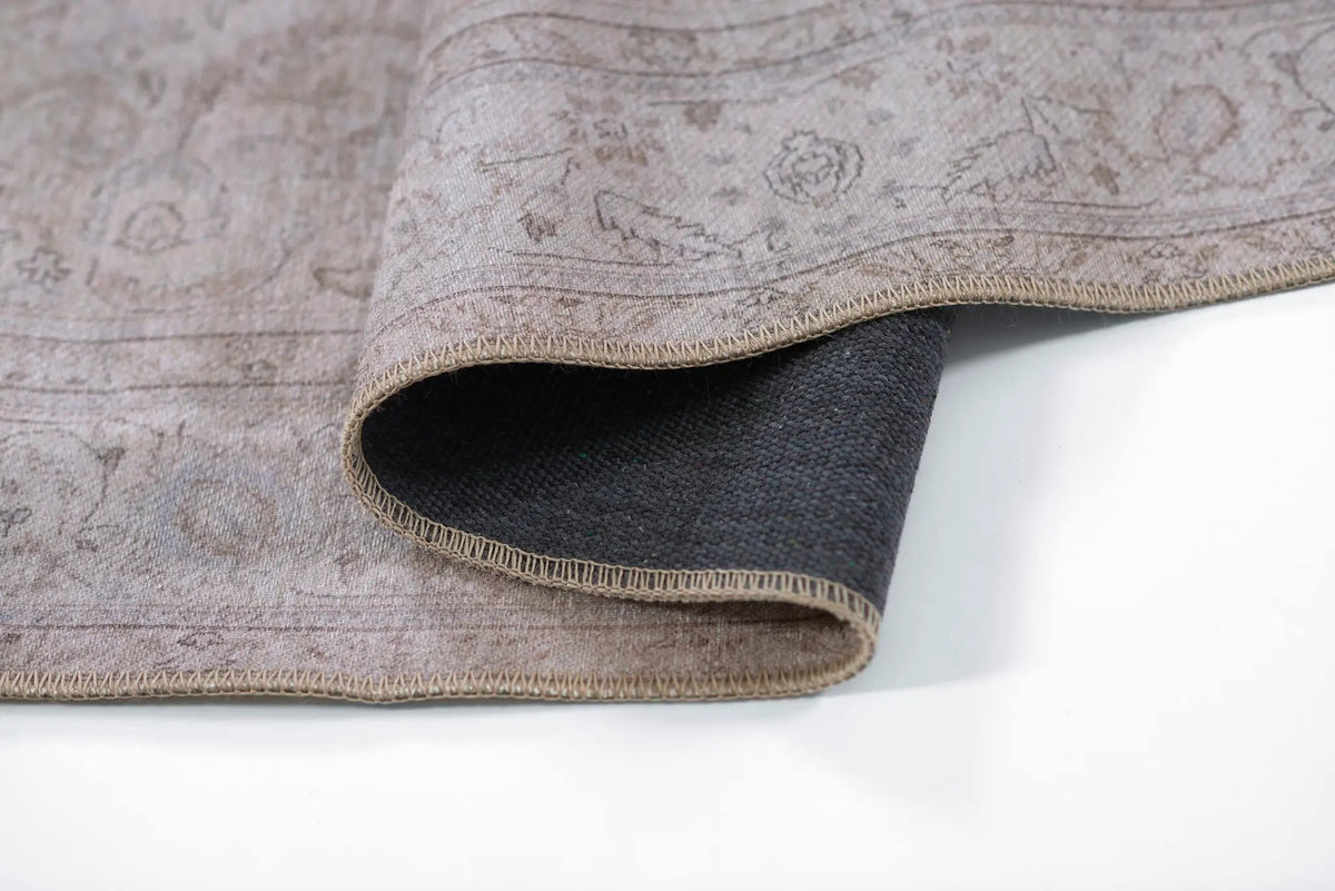Folded corner of Erin Gates by Momeni Dorset DOR-4 gray area rug showing subtle vintage pattern, stitched binding, and dark backing.