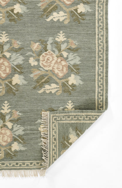 Momeni Florence FLO-1 Blue floral wool area rug with Bessarabian-inspired rose motifs, blush tones, decorative border, and fringed edges.