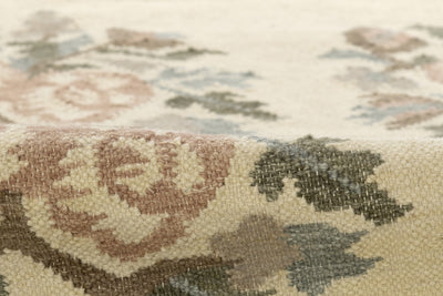 Momeni Florence FLO-1 ivory floral wool area rug with Bessarabian-style rose bouquet design, subtle blue and blush accents, ornamental border, and fringe.