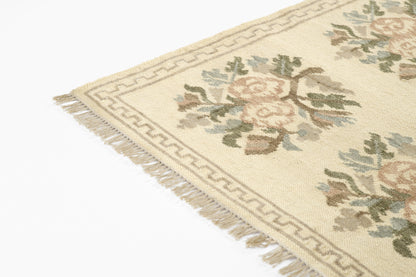 Momeni Florence FLO-1 ivory floral wool area rug with Bessarabian-style rose bouquet design, subtle blue and blush accents, ornamental border, and fringe.