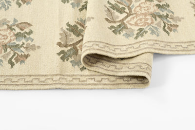 Momeni Florence FLO-1 ivory floral wool area rug with Bessarabian-style rose bouquet design, subtle blue and blush accents, ornamental border, and fringe.
