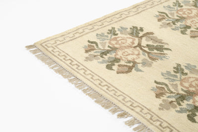 Momeni Florence FLO-1 ivory floral wool area rug with Bessarabian-style rose bouquet design, subtle blue and blush accents, ornamental border, and fringe.