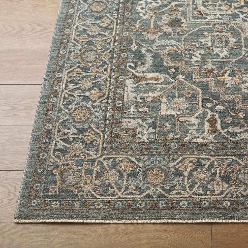 Close-up of a Arda ACZ-2306 deep teal area rug with a traditional pattern and fringe on light wood flooring.