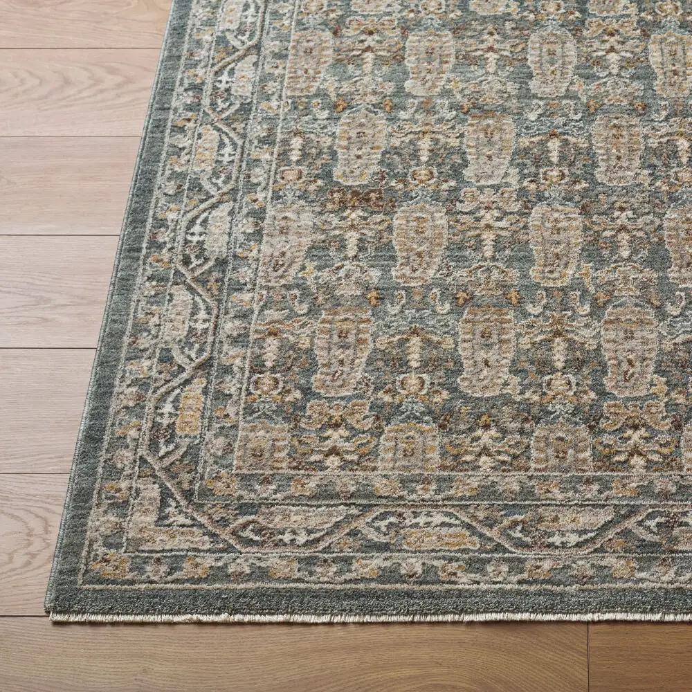 Close-up of the Arda ACZ-2309 dark green area rug with an intricate pattern and fringe on wood floor.