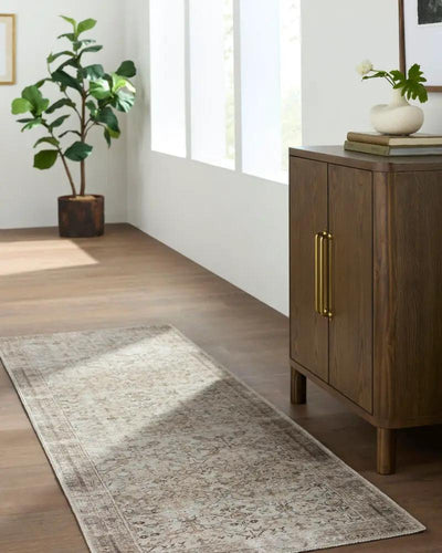 Amelia JYAL-2301 Ivory Area Rug runner in a hallway next to a wooden cabinet and potted plant.