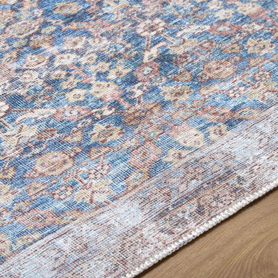 Close-up of the Amelia Slate Blue Area Rug showing its distressed floral pattern and low pile.