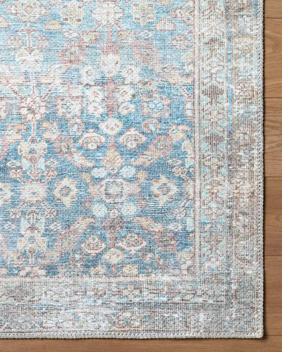 Close-up of the Amelia Sky Blue Area Rug featuring a faded medallion pattern in blue and tan.