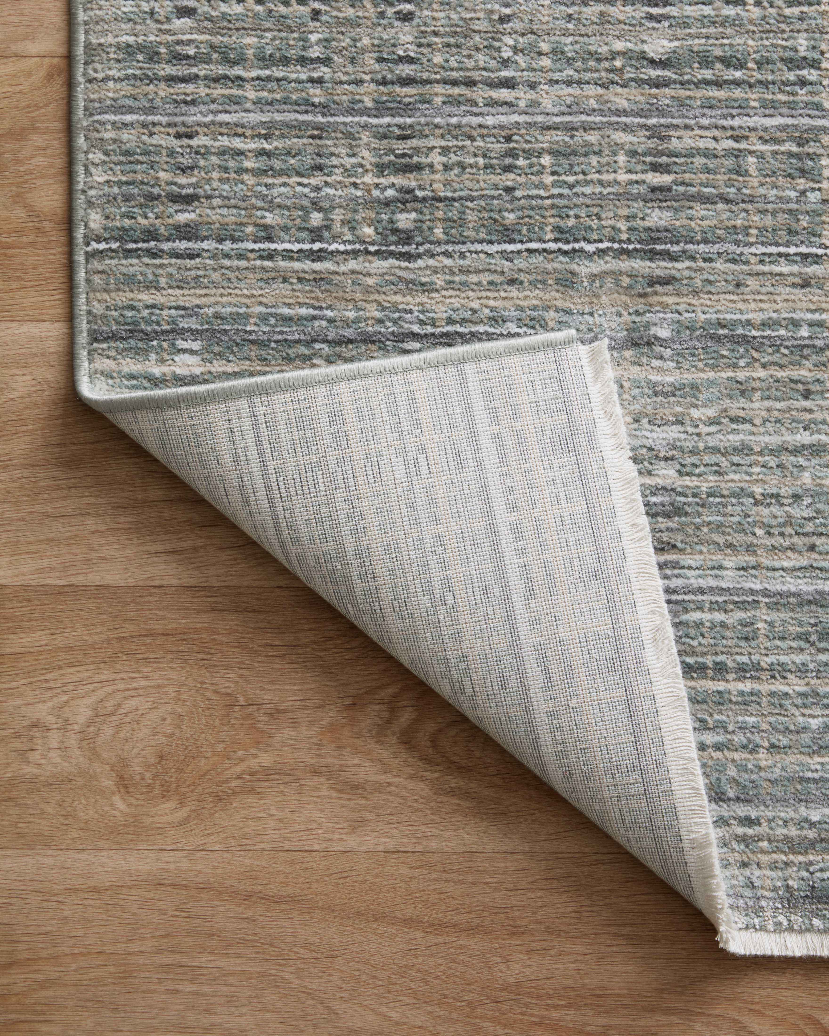 The Soho SOH-04 Jade / Stone Area Rug delivers refreshing jade and grounding stone beauty and contemporary and abstract elegance in a power-loomed 100% polyester area rug