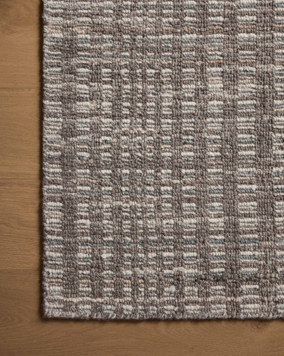 Dressed in striking granite and vibrant multi-toned hues with graphic detail, the Sonya SOY-05 Granite / Multi Area Rug is a hand-loomed wool area rug that completes any room