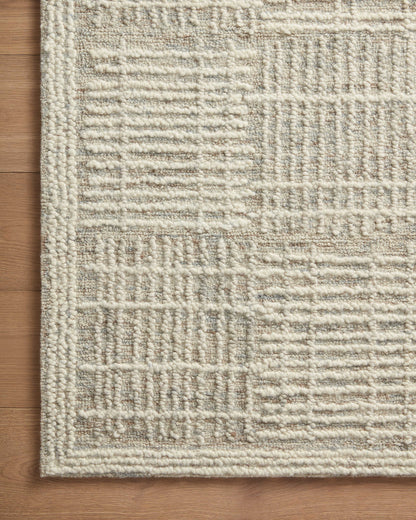 A hand-tufted 100% wool area rug with abstract and linear flair in soft misty and refined ivory tones, the Tallulah TLL-02 Mist / Ivory Area Rug anchors any room