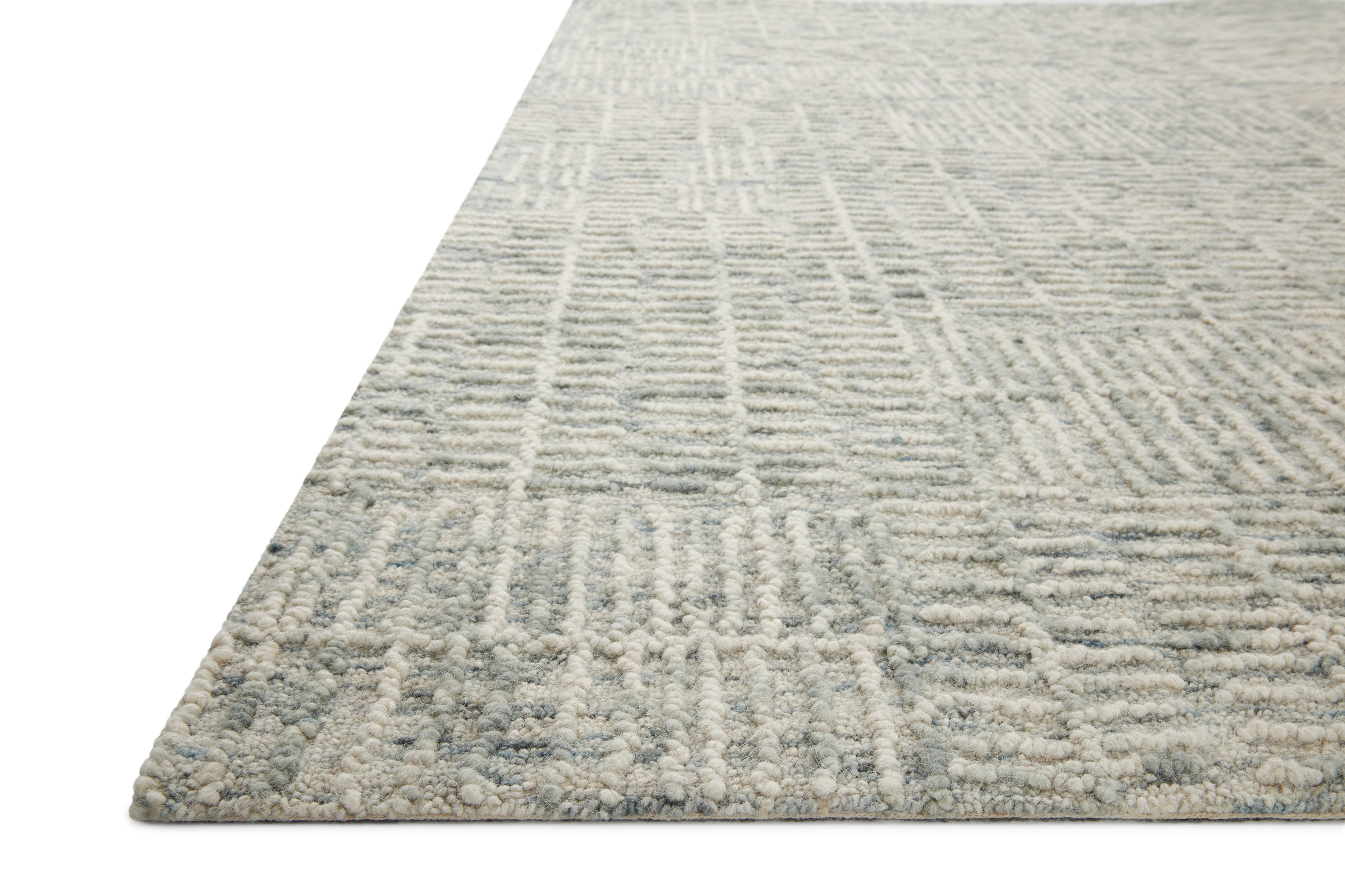 The Tallulah TLL-03 Sky / Ivory Area Rug pairs breezy sky-blue and refined ivory tones and abstract and linear patterns in a hand-tufted 100% wool area rug