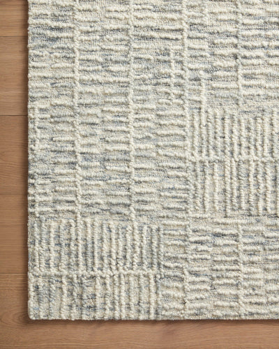 The Tallulah TLL-03 Sky / Ivory Area Rug pairs breezy sky-blue and refined ivory tones and abstract and linear patterns in a hand-tufted 100% wool area rug