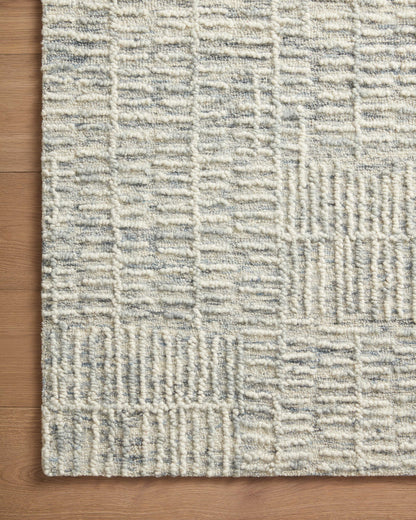 The Tallulah TLL-03 Sky / Ivory Area Rug pairs breezy sky-blue and refined ivory tones and abstract and linear patterns in a hand-tufted 100% wool area rug