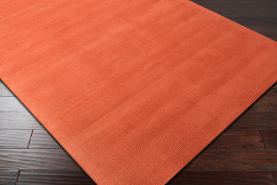 Hand-crafted Livabliss Mystique M-332 burnt-orange wool area rug with structured high/low pile weave on dark and light wood flooring.