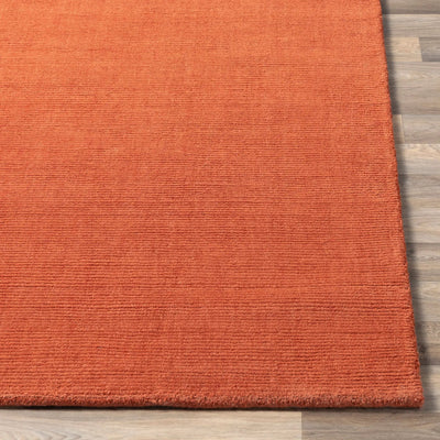 Livabliss Mystique M-332 Burnt-orange wool area rug with textured horizontal weave laid on light wood flooring to add warmth and depth to living spaces.