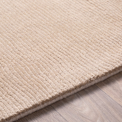 Livabliss Mystique M-335 Tan hand-loomed Indian wool area rug with textured high-low pile, corner resting on wood floor for modern interiors.