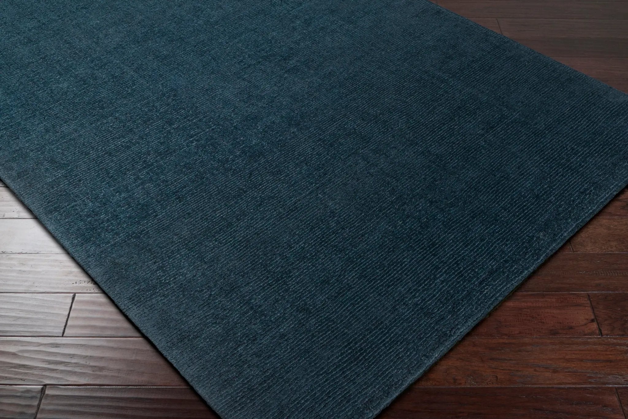 Livabliss Mystique M-340 Dark blue hand-loomed wool area rug with high-low pile texture on two-tone wood flooring.