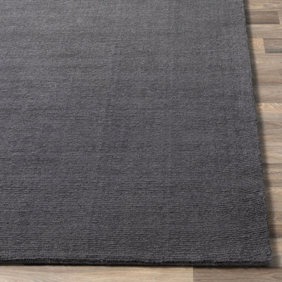 Livabliss Mystique M-341 Charcoal wool area rug with textured high-low pile surface laid on light wood flooring, showcasing hand-loomed craftsmanship.