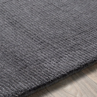 Livabliss Mystique M-341 Charcoal high-low pile wool area rug with hand-loomed texture and modern silhouette resting on wood flooring.