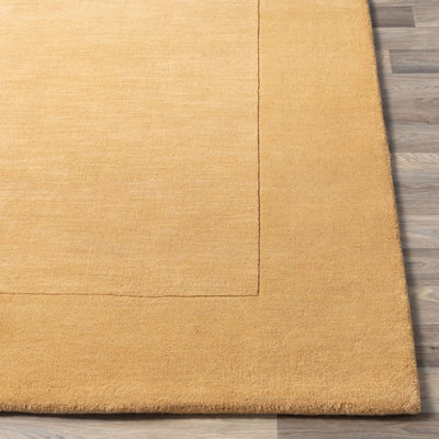 Livabliss Mystique M-345 Camel color area rug with textured surface and tonal border design, laid over light wood flooring for a warm, contemporary look.