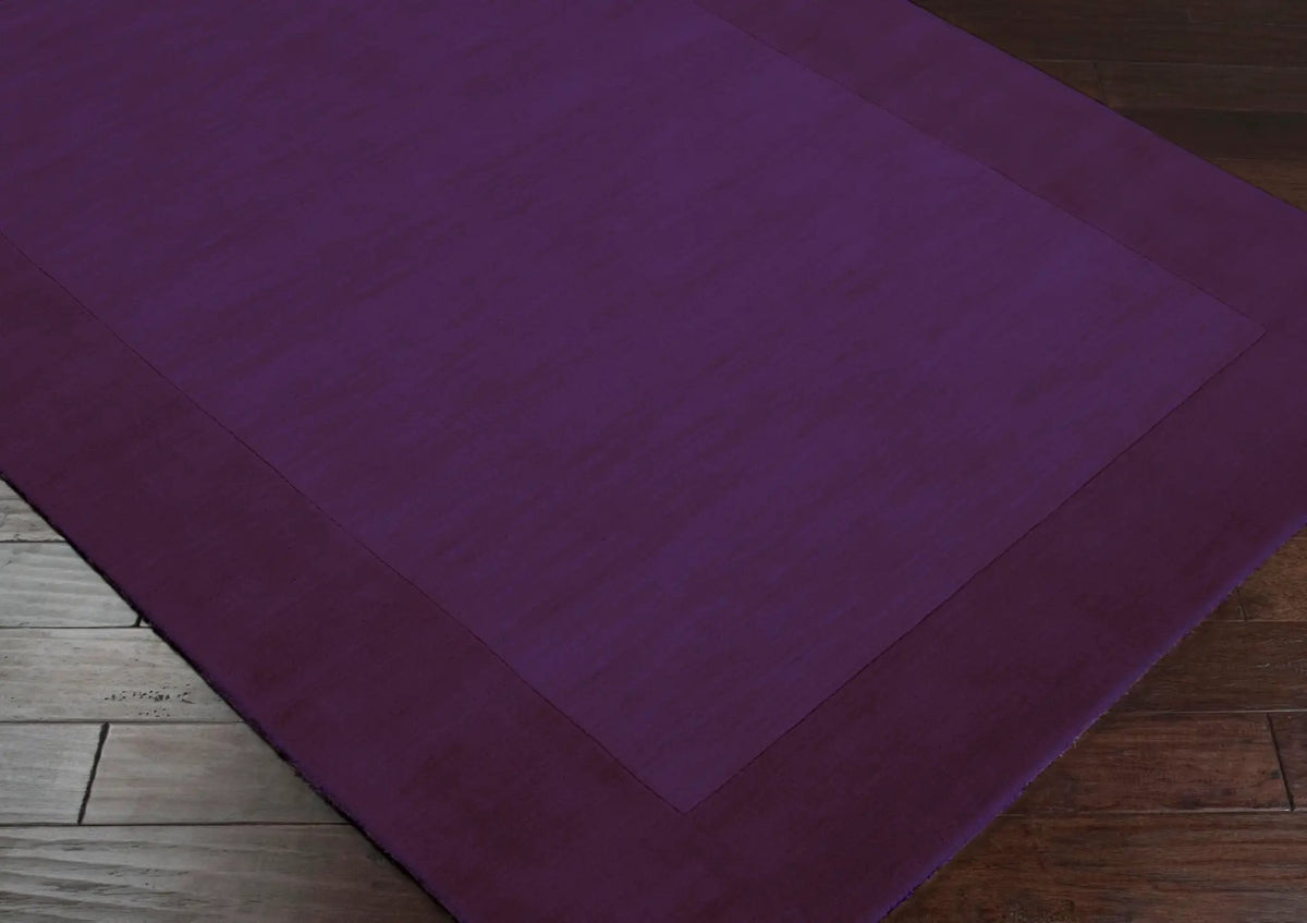 Deep purple hand-loomed wool Livabliss Mystique M-349 area rug with border detail, showcasing artisan craftsmanship from India on hardwood flooring.