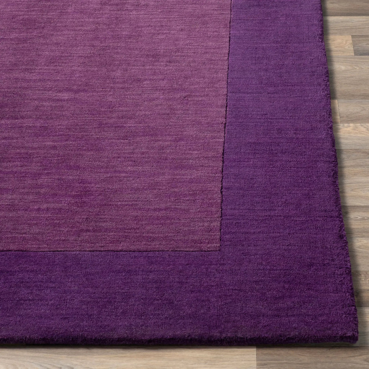 Livabliss Mystique M-349 Purple area rug with hand-loomed wool texture featuring a lighter center field and darker border on wood flooring.