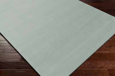 Livabliss Mystique M-5328 dusty sage area rug featuring hand-loomed wool texture and high-low pile on dark hardwood flooring.