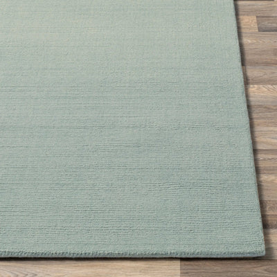 Livabliss Mystique M-5328 dusty sage area rug with textured high-low pile and plush wool surface resting on hardwood flooring.