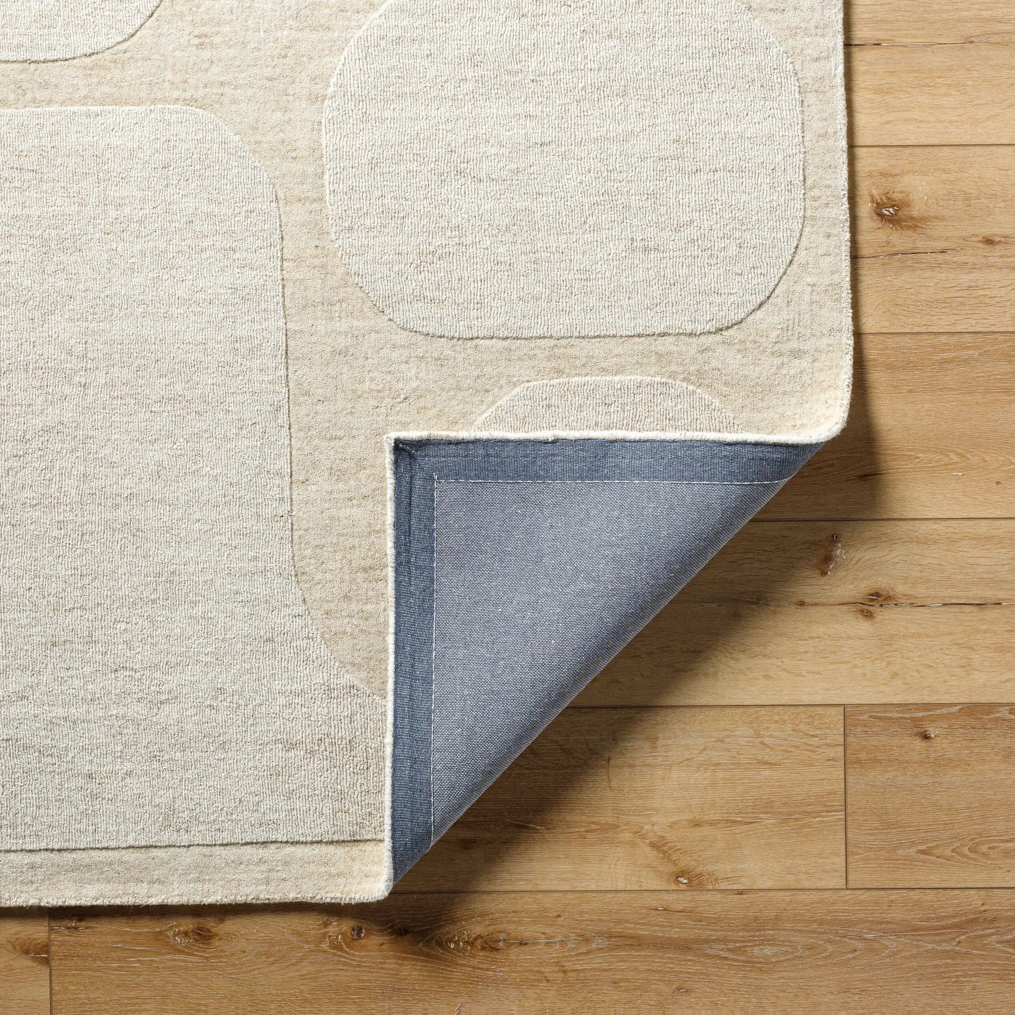 Livabliss Mystique M-5476 Beige hand-loomed wool area rug with raised geometric pattern and durable blue backing on hardwood floor.