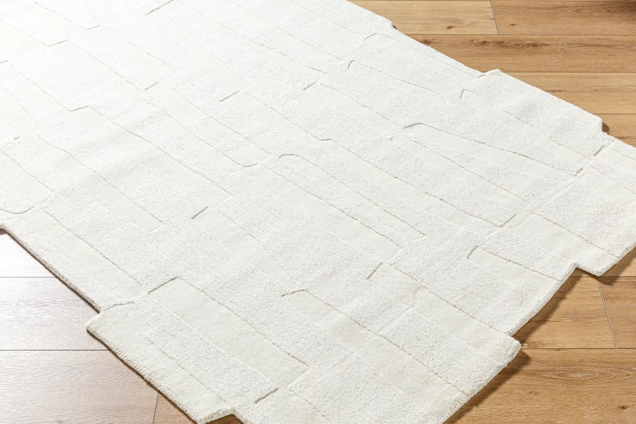Livabliss Mystique M-5489 Ivory hand-loomed wool area rug with textured geometric pattern and medium pile laid over hardwood flooring.