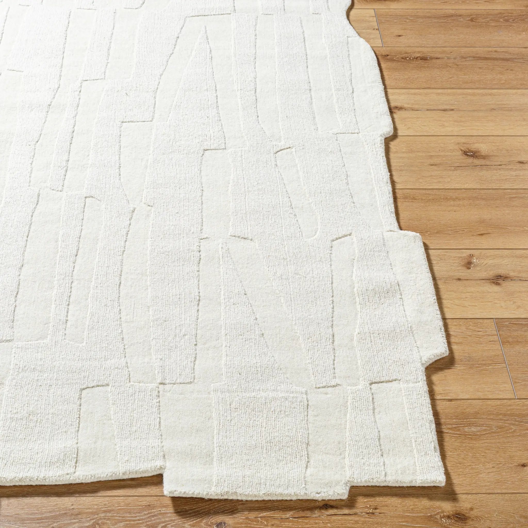 Livabliss Mystique M-5489 Ivory hand-loomed wool area rug with abstract textured pattern and medium pile on hardwood floor.