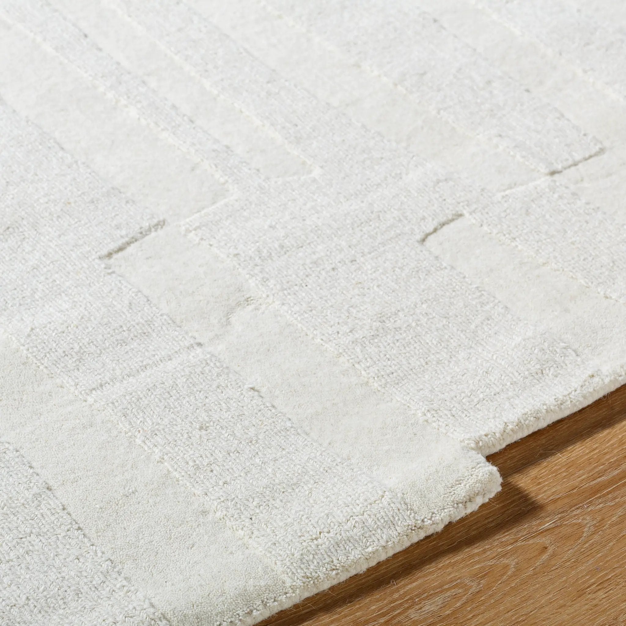 Livabliss Mystique M-5489 Ivory hand-loomed wool area rug with textured geometric pattern and medium pile resting on hardwood flooring.