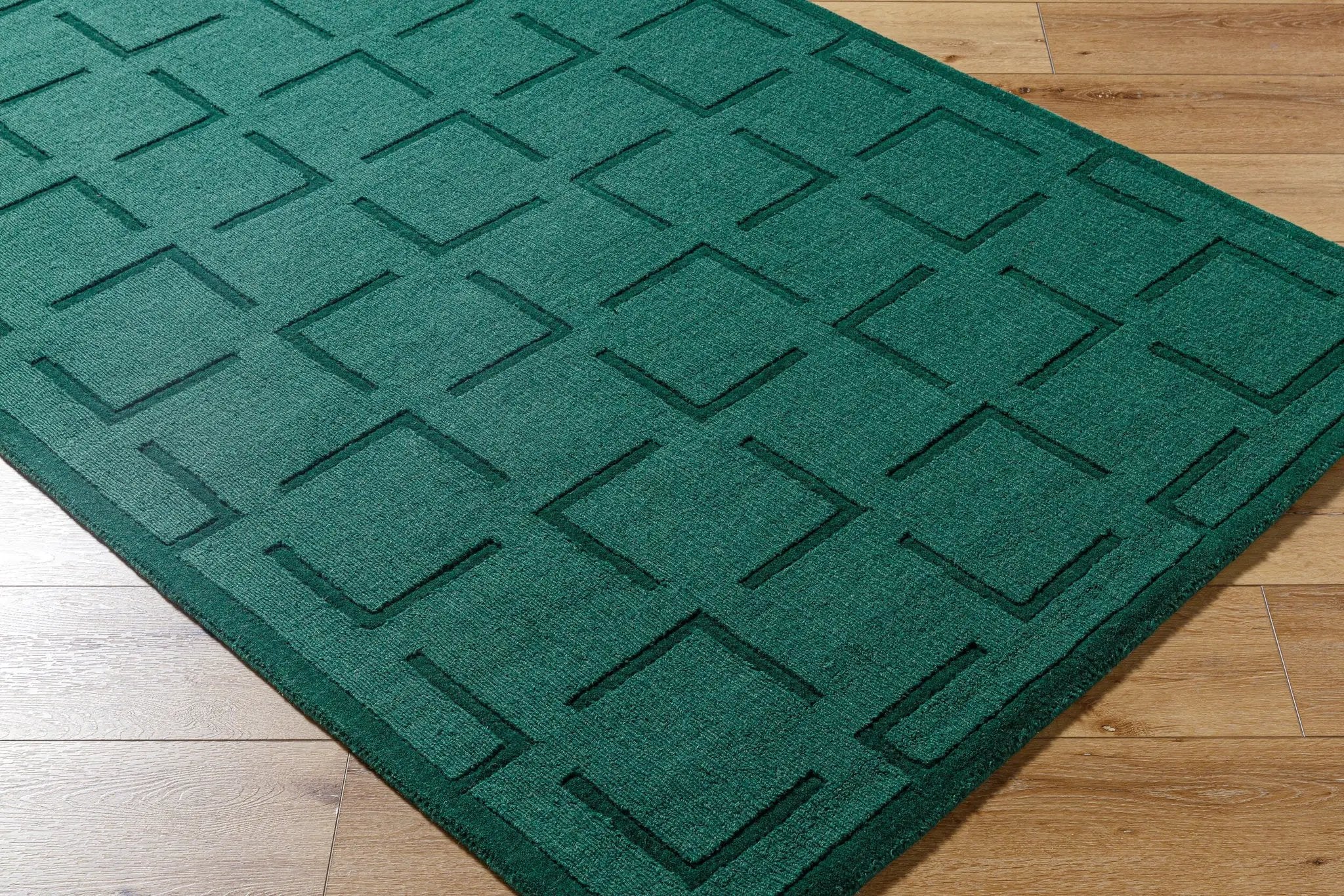 Livabliss Hand Loomed Mystique M-5490 Emerald Green area rug featuring a geometric diamond pattern and textured wool pile on a wooden floor.
