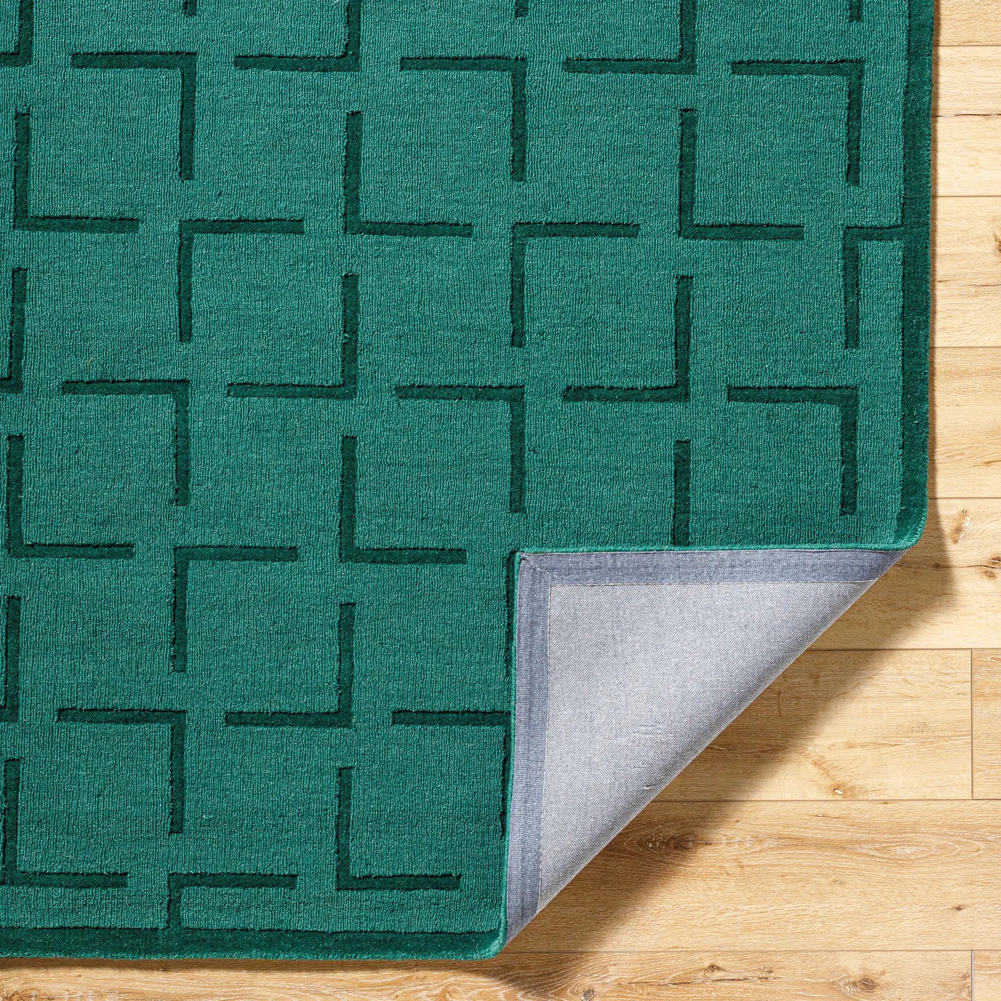 Livabliss Hand Loomed Mystique M-5490 Emerald Green wool area rug with geometric pattern and grey backing, corner lifted on light wood floor.