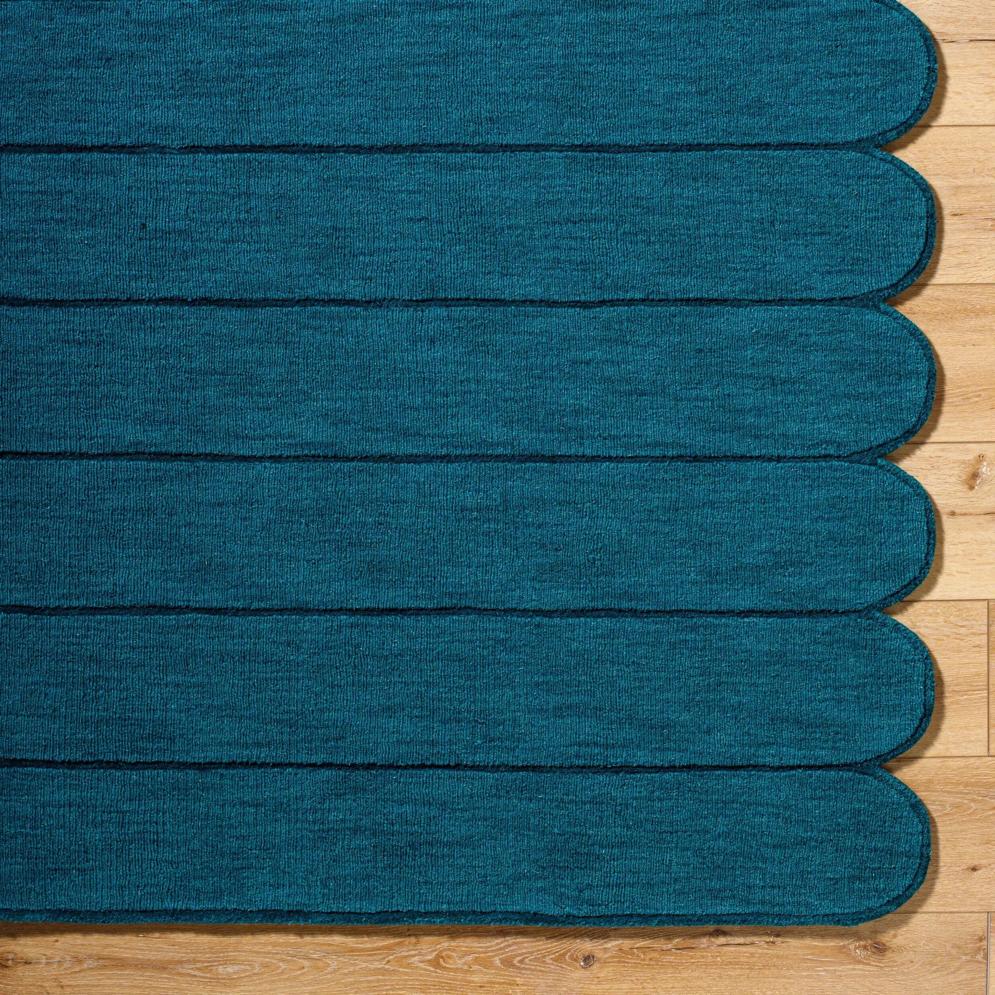 Livabliss Hand Loomed Mystique M-5491 Teal wool area rug with medium-pile texture and distinctive scalloped edge resting on hardwood flooring.