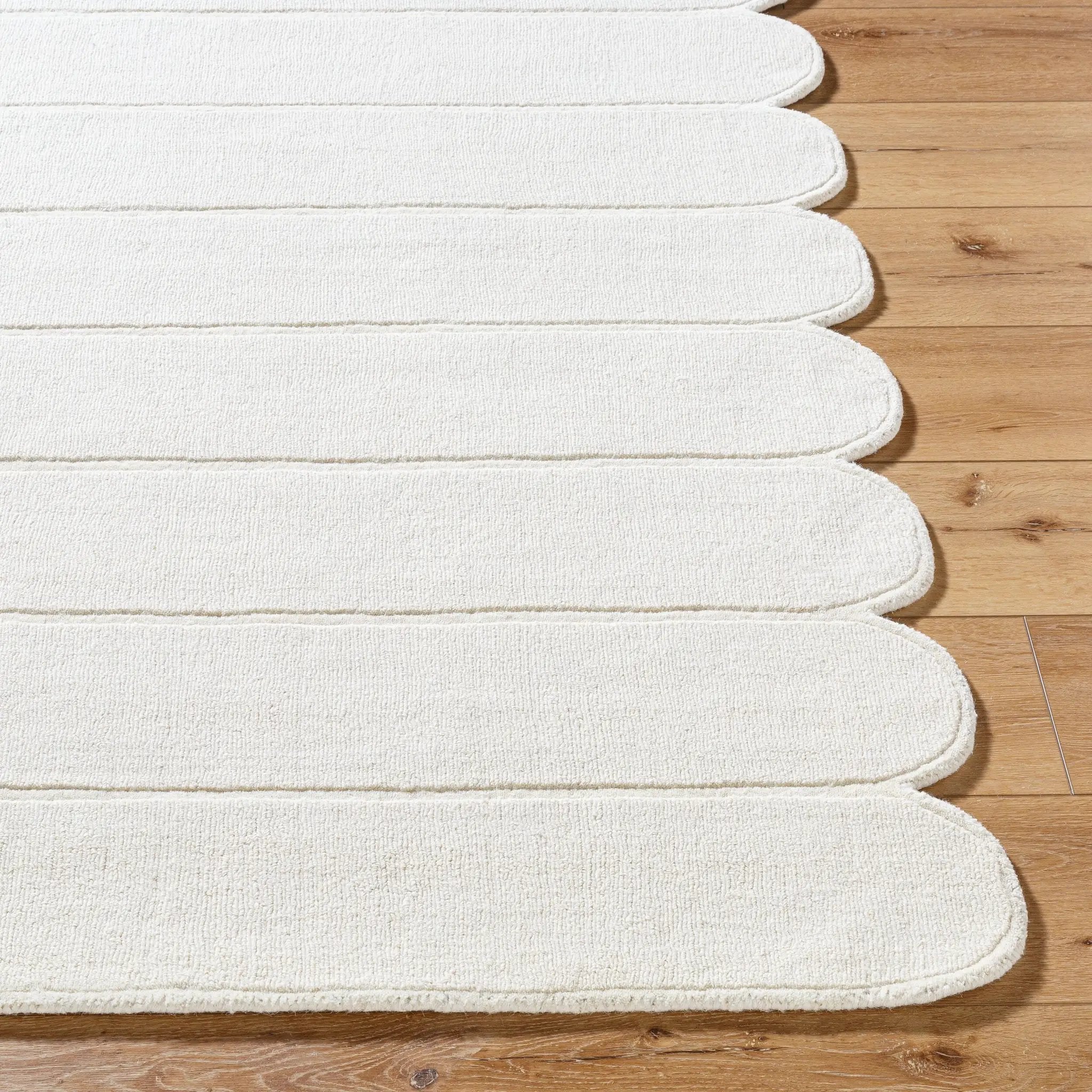 Livabliss Mystique M-5492 Ivory hand-loomed wool area rug featuring a balanced medium pile and decorative scalloped edge on hardwood flooring.