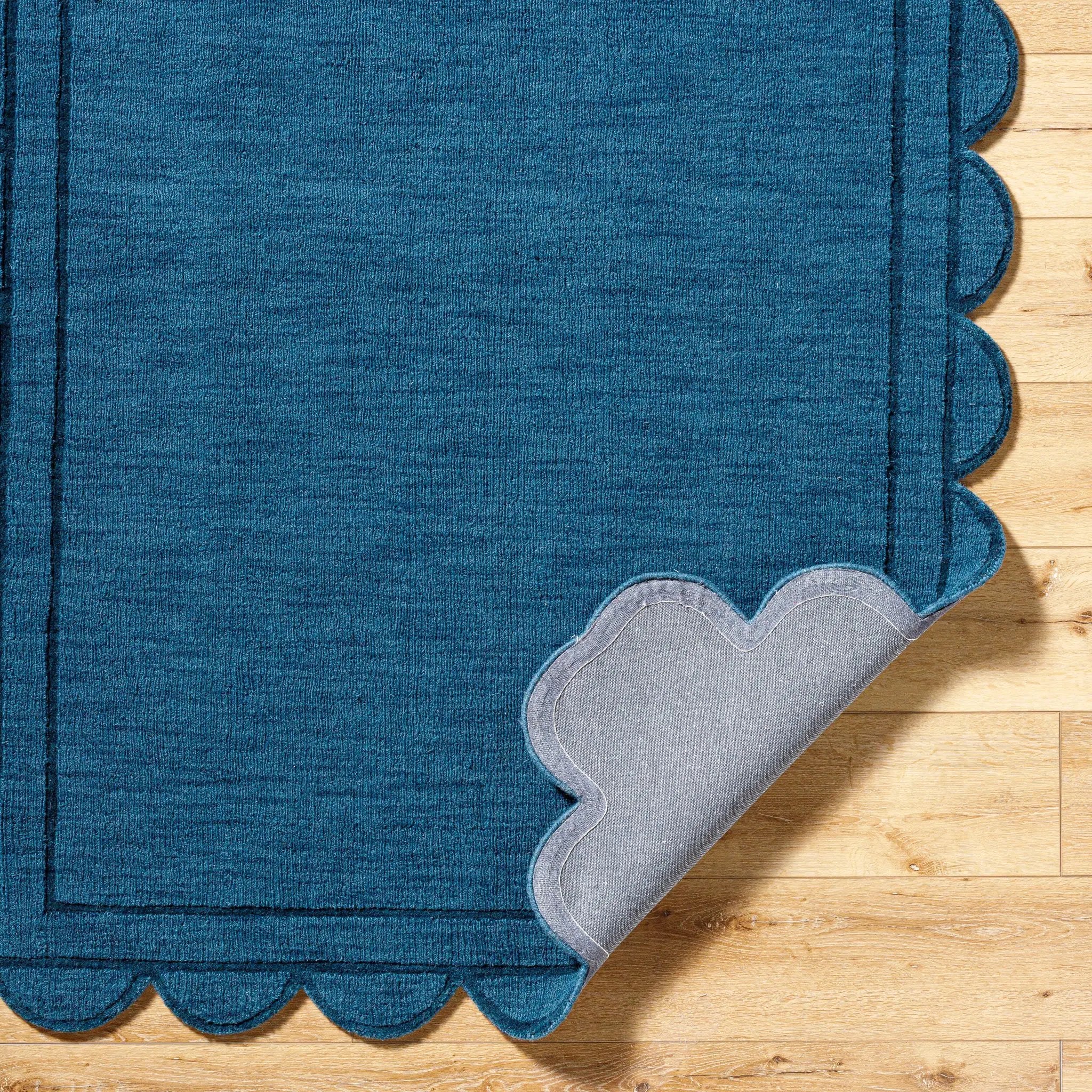 Livabliss Mystique M-5493 Indigo hand loomed wool area rug with scalloped edges and gray backing on hardwood floor.