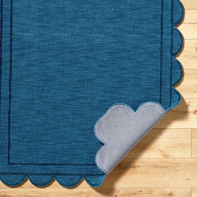 Livabliss Mystique M-5493 Indigo hand loomed wool area rug with scalloped edges and gray backing on hardwood floor.