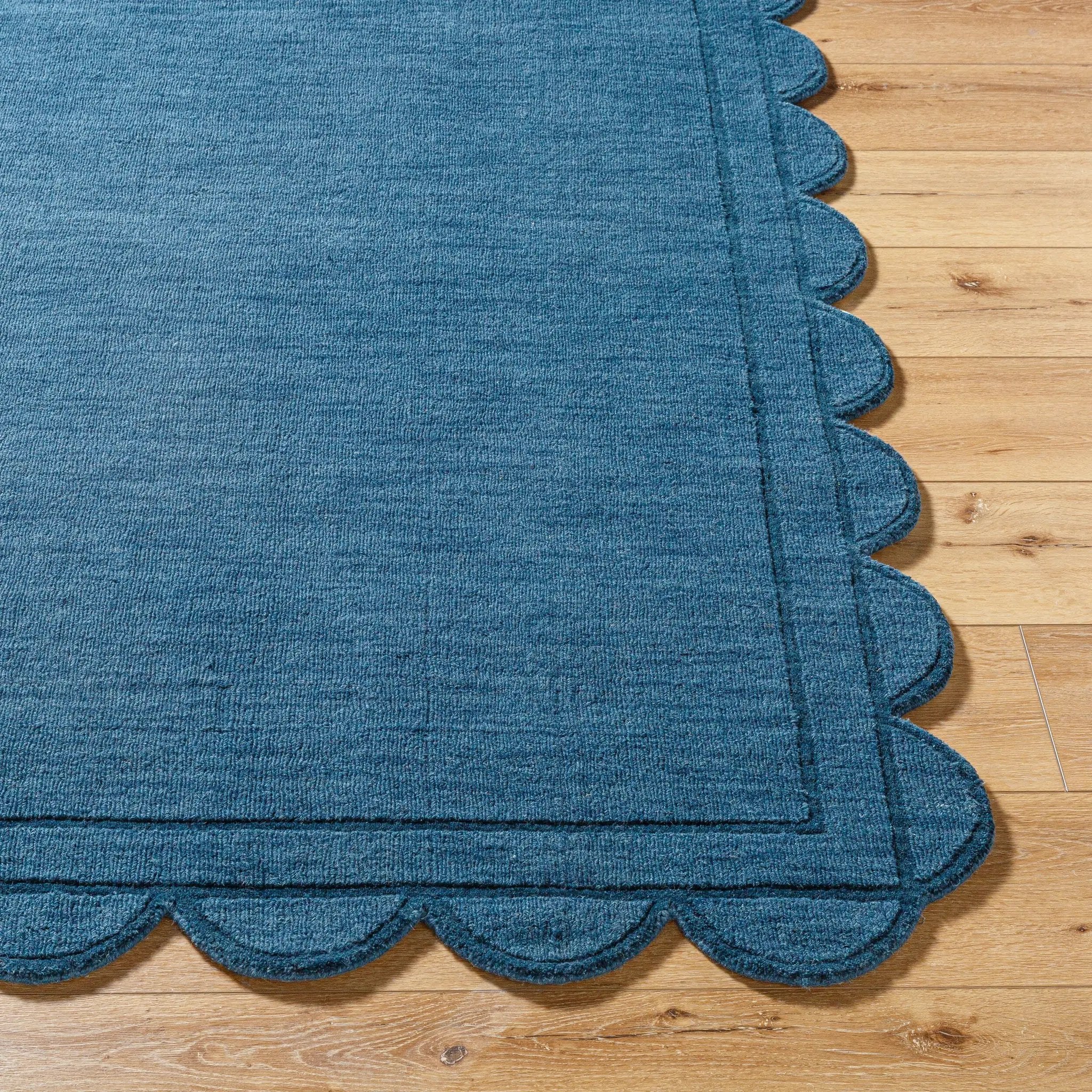 Livabliss Mystique M-5493 Indigo hand loomed wool area rug featuring a soft medium pile and distinctive scalloped edge resting on light hardwood flooring.