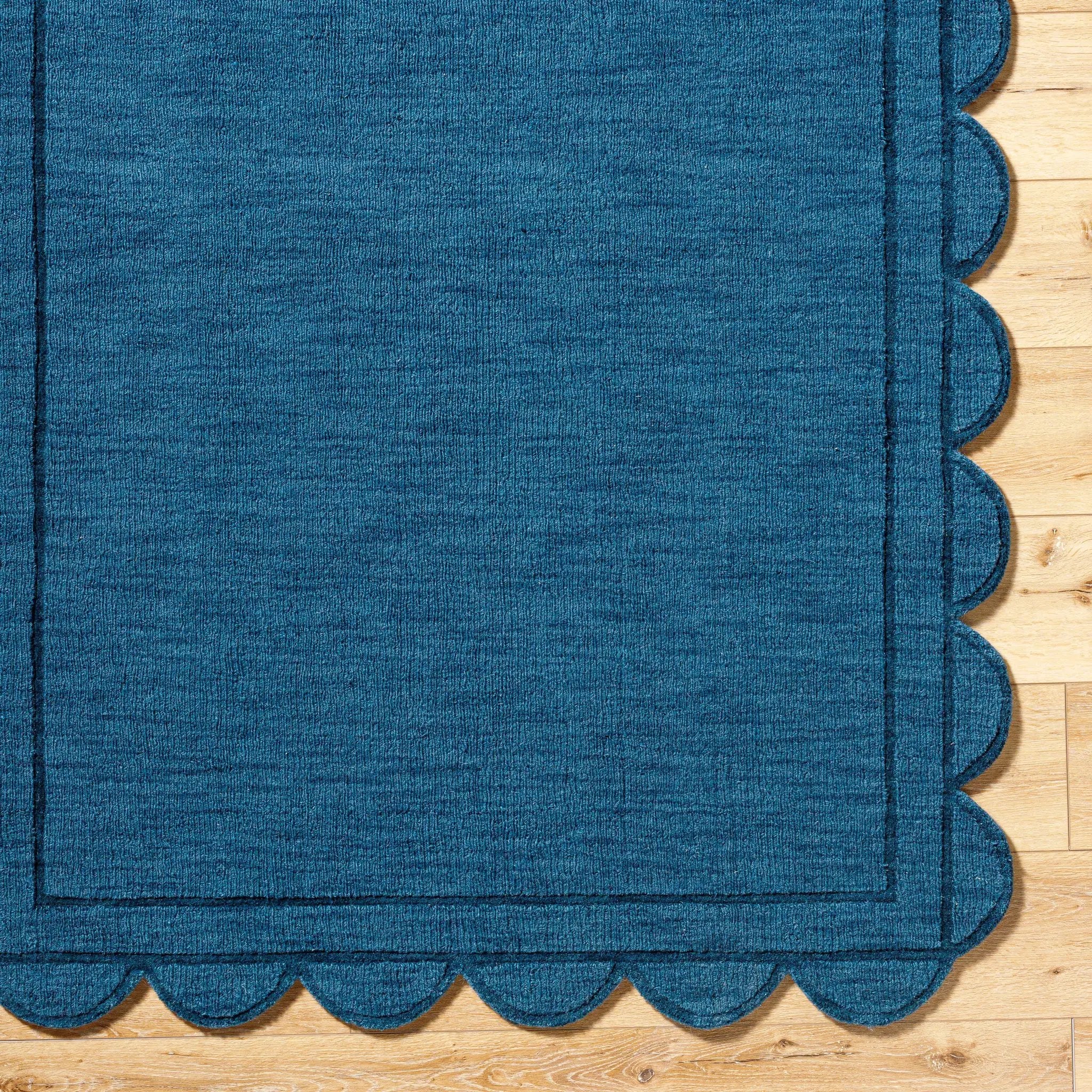 Livabliss Mystique M-5493 Indigo wool area rug with scalloped edges and border, showcasing handcrafted texture on hardwood floor.