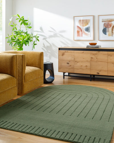 Livabliss Mystique M-5495 Sage green wool hand-loomed area rug with a concentric arch pattern anchors a modern living room with a mustard sofa and a wood sideboard.
