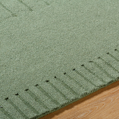 Livabliss Mystique M-5495 Sage green area rug with handcrafted texture and subtle geometric pattern resting on light wood flooring.