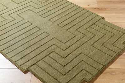 Livabliss Mystique M-5497 Olive green hand-loomed wool area rug featuring a textured geometric chevron pattern laid on light hardwood flooring.
