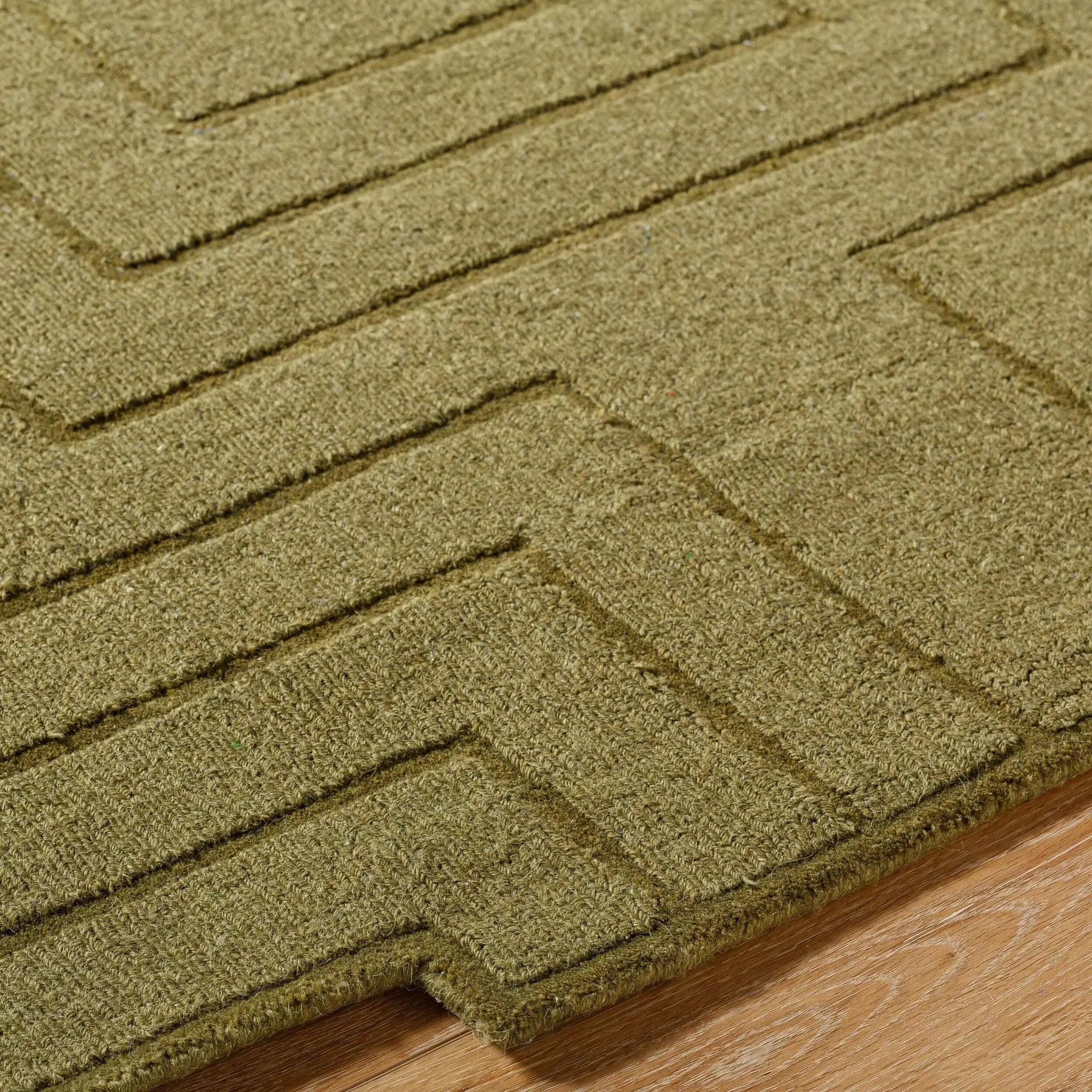 Livabliss Mystique M-5497 Olive green hand-loomed wool area rug with geometric pattern and durable texture on wood flooring.