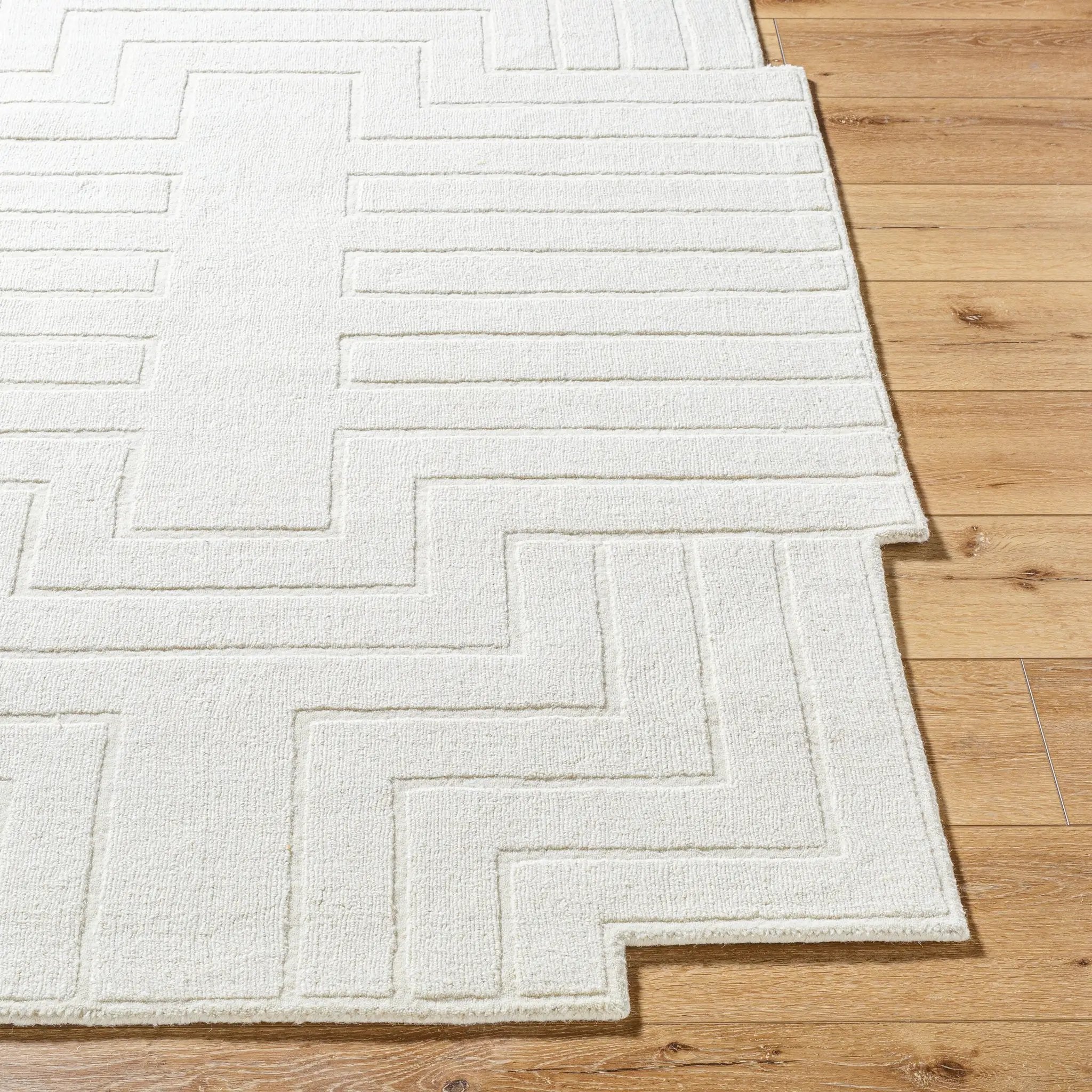 Livabliss Mystique M-5498 Ivory wool hand-loomed area rug featuring a geometric maze pattern and medium pile, laid on light wood flooring.