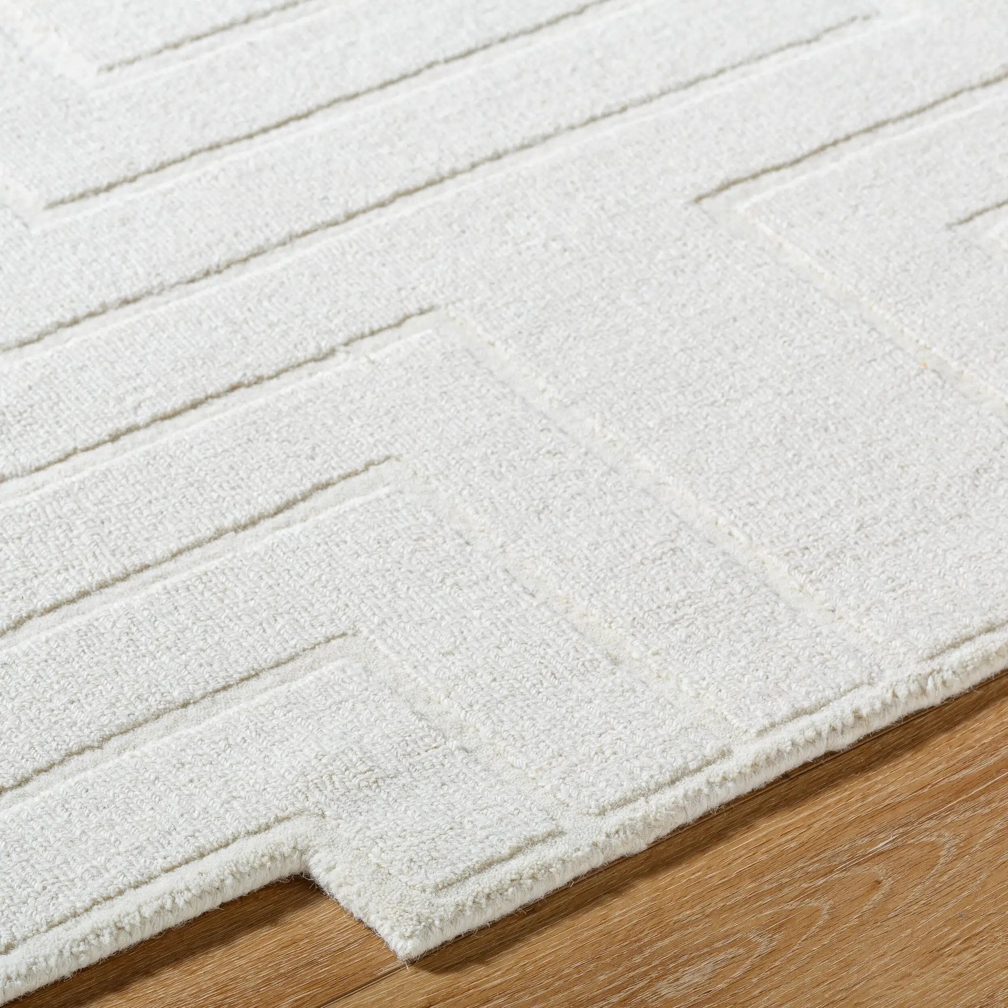 Livabliss Mystique M-5498 Ivory hand-loomed wool area rug with subtle geometric texture and medium pile resting on hardwood flooring.