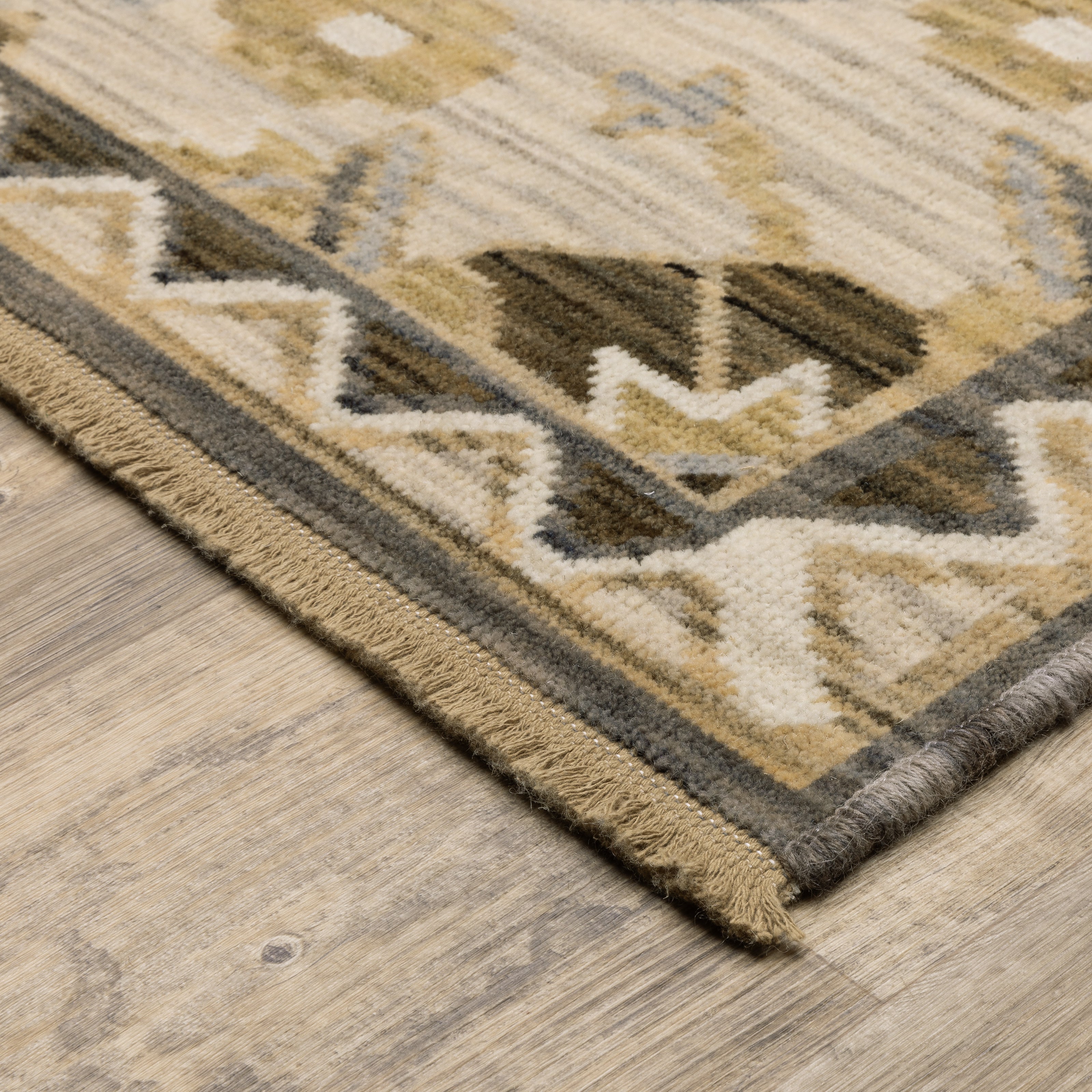 Acacia ACA03 Tan/Grey traditional area rug with earthy tan, grey, brown, gold, blue, clay, and green tones and cotton fringe.
